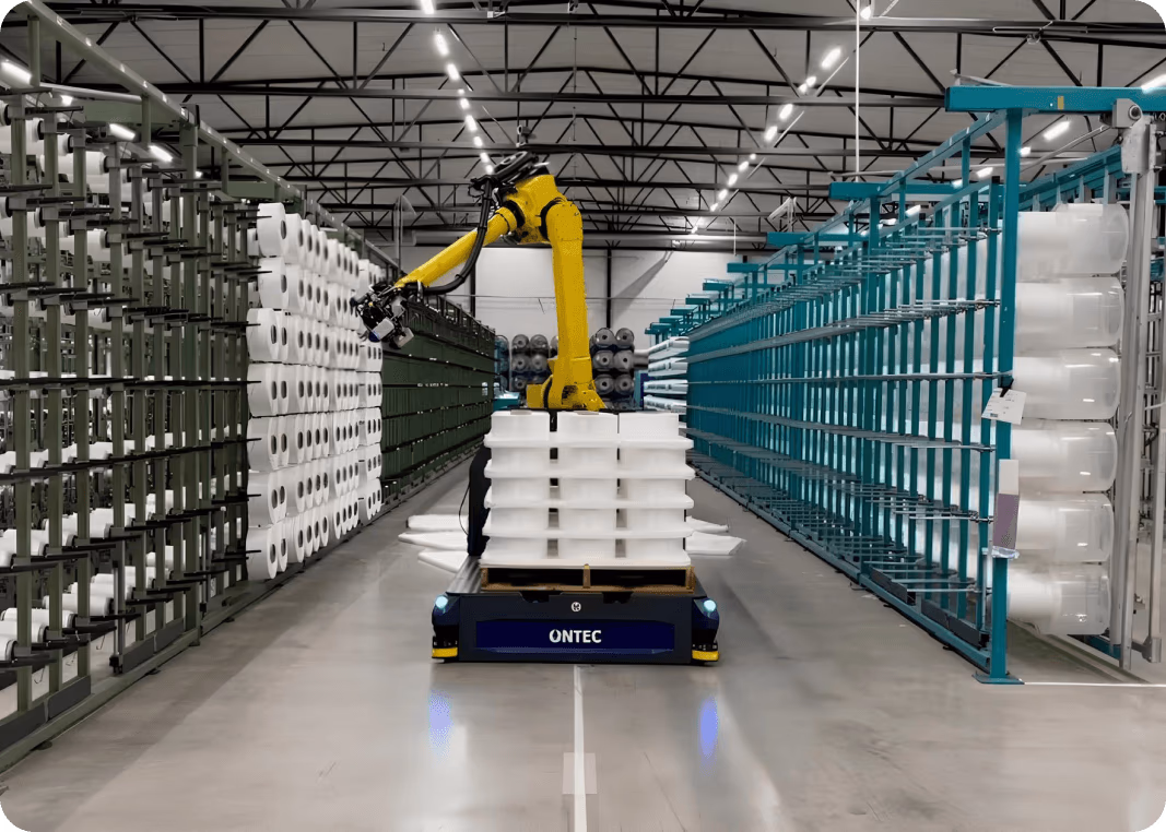 Un véhicule autonome avec des bras robotisés chargeant des bobines