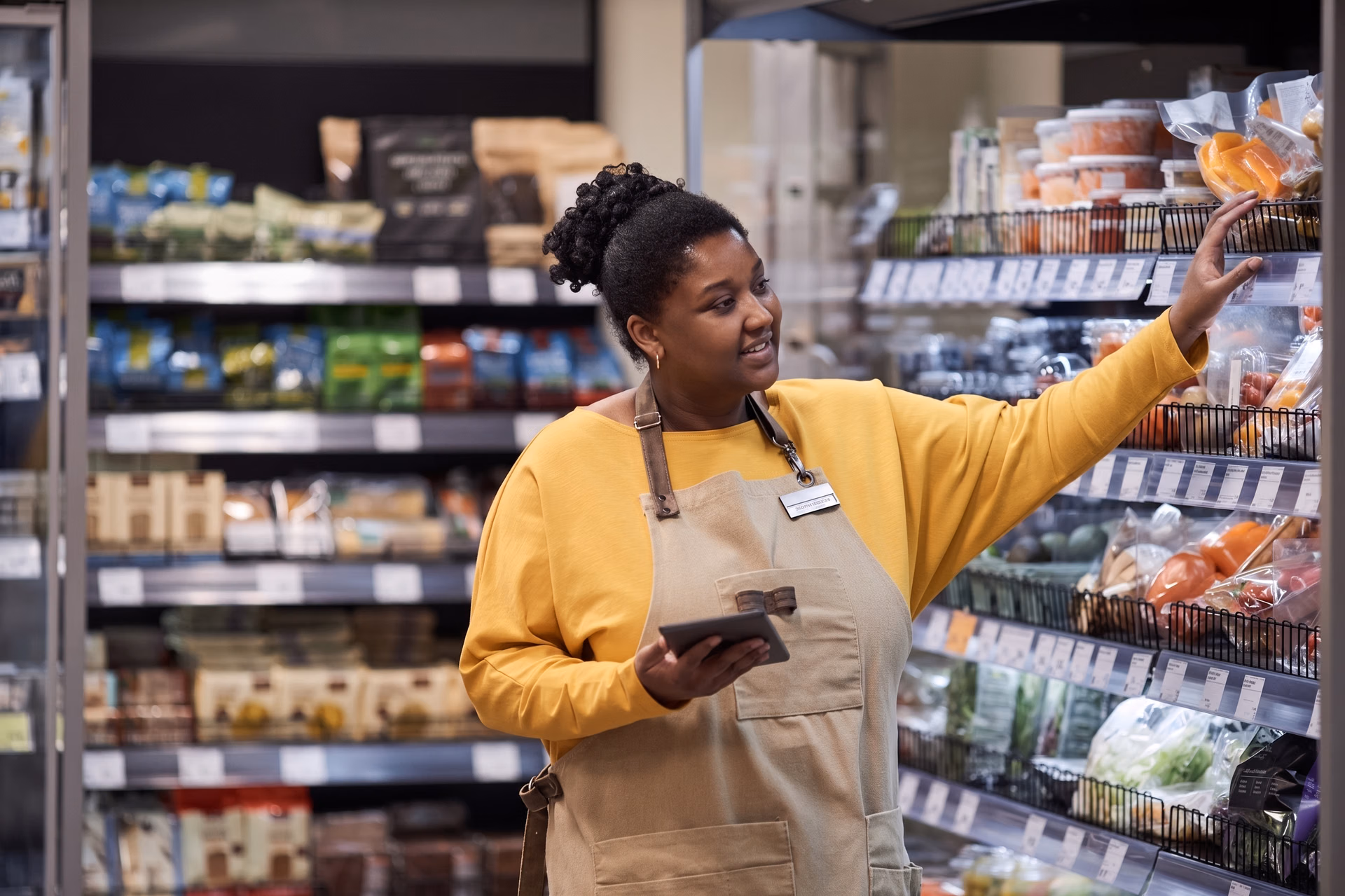 A store worker restocking fresh produce for customers