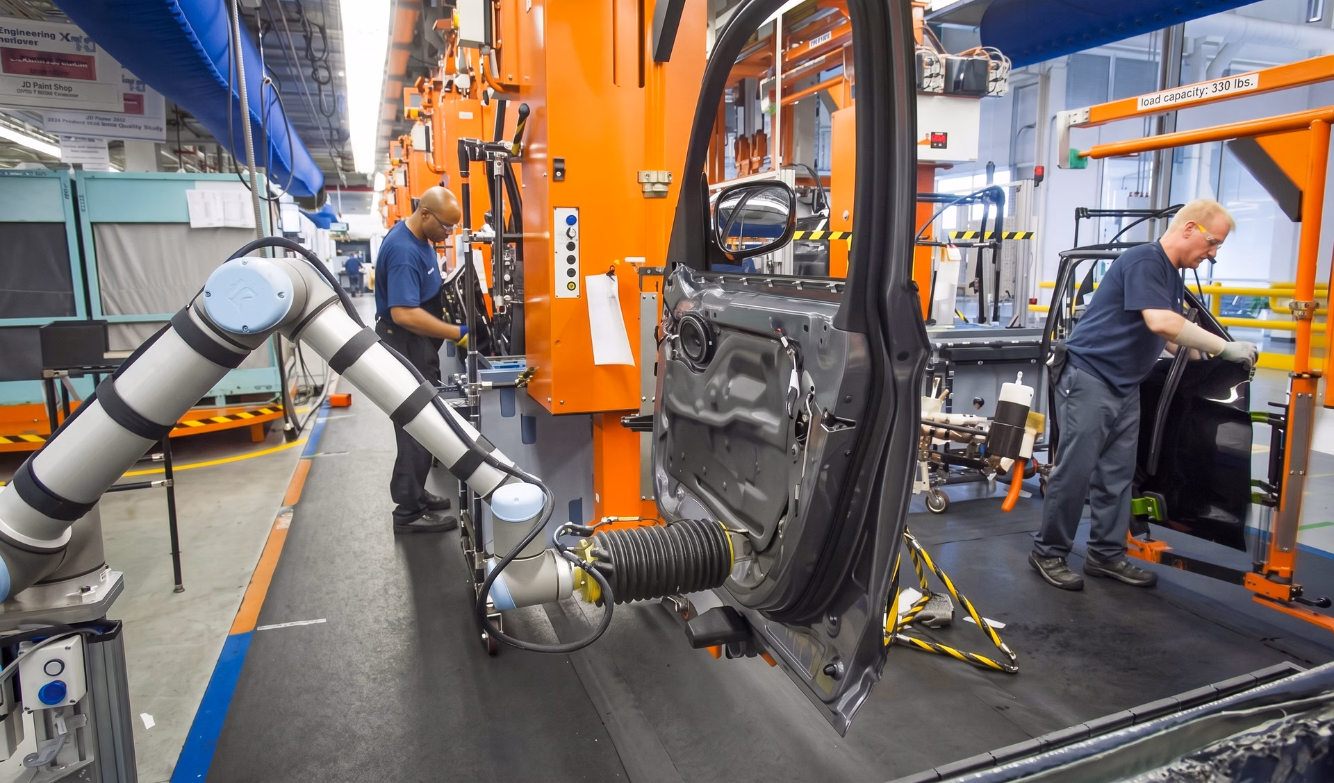 Robots working alongside workers at a car manufacturing plant