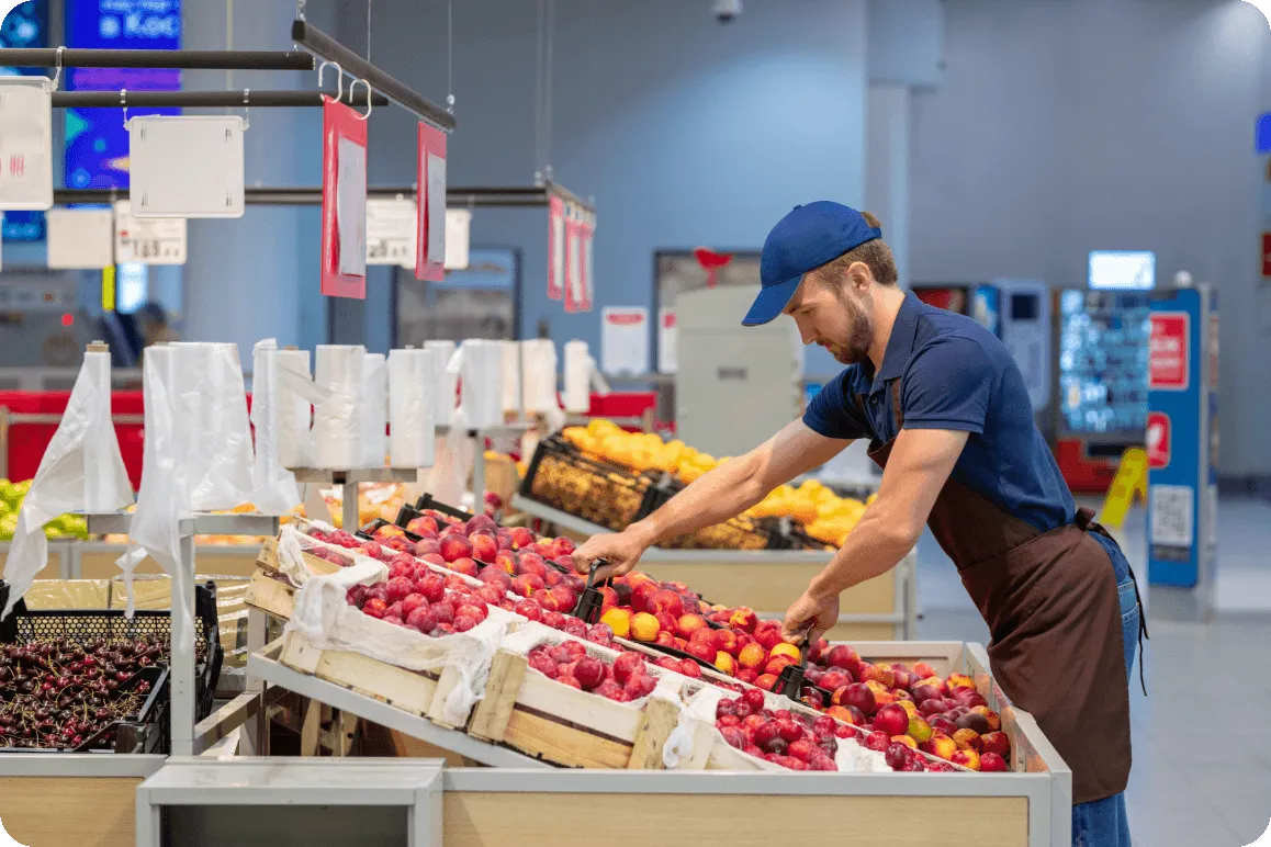 Staff restocking fruit at a retail store