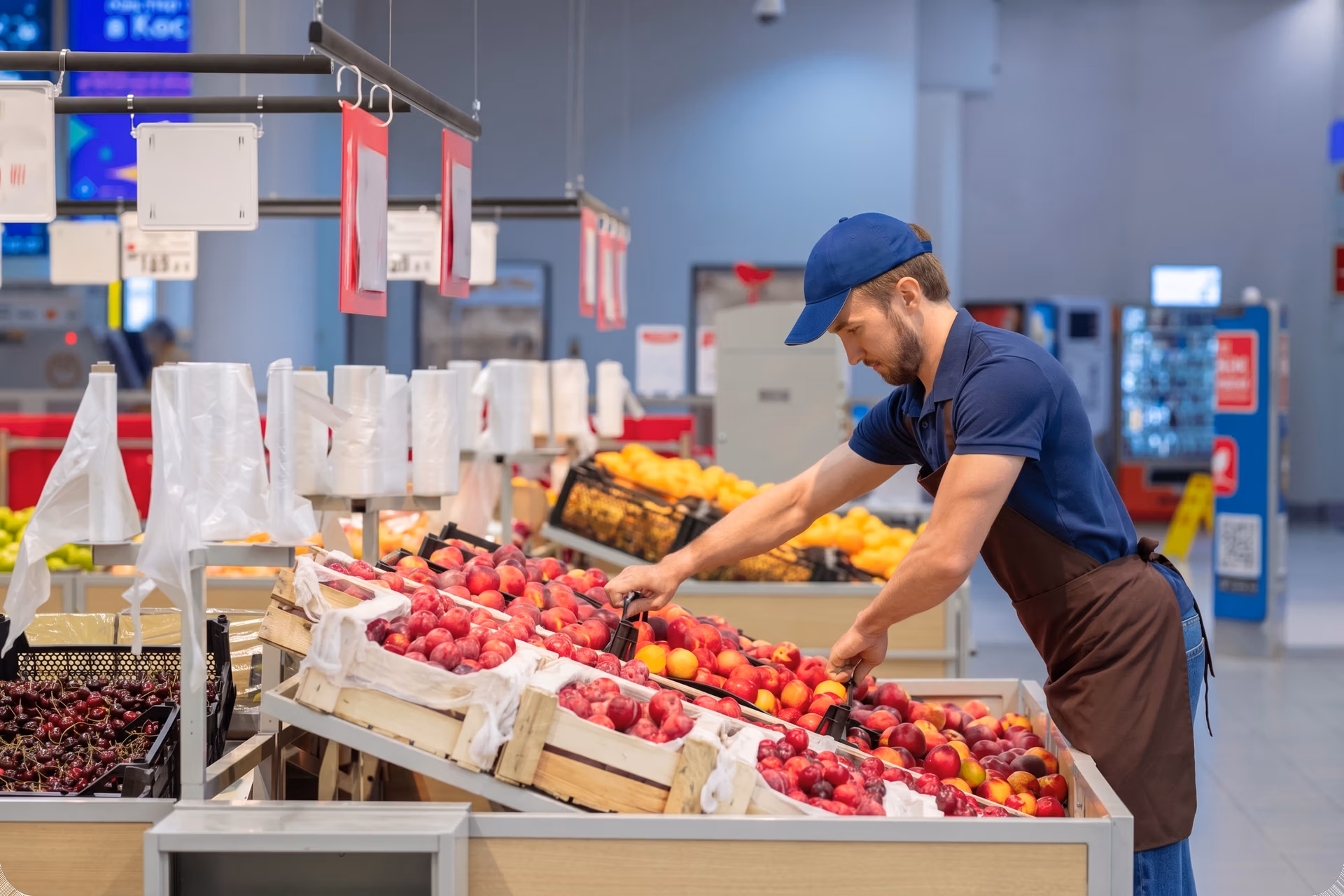 Staff restocking fruit at a retail store