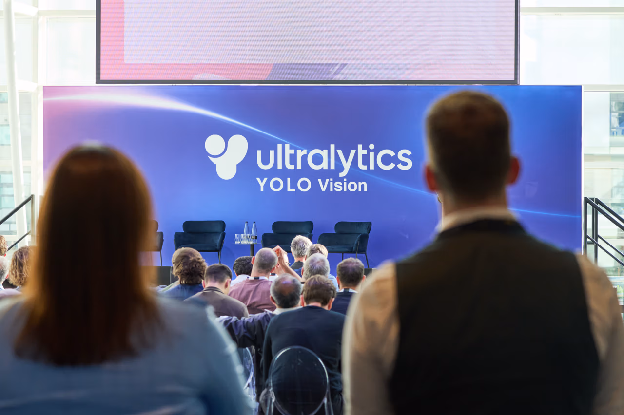 Ultralytics YOLO Vision 메인 무대에서 세션을 시청하고 있는 참석자들